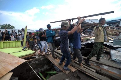 Varios ciudadanos trasladan el cuerpo de una víctima en la localidad indonesia de Palu. OLAGONDRONK