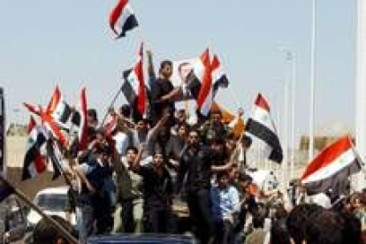 Ciudadanos sirios muestran banderas nacionales para celebrar el retorno de sus tropas