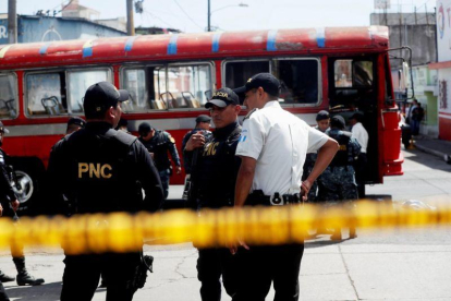 Policias expertos en explosivos trabajan en el lugar donde se produjo la detonacion de una granada en un autobus de pasajeros en Ciudad de Guatemala.