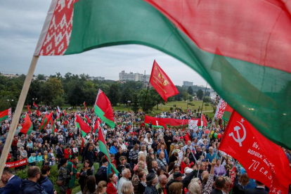 Manifestantes portan banderas de Bielorrusia en una marcha en apoyo a Lukashenko. TATYANA ZENKOVICH