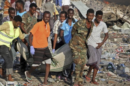 Traslado de un cadáver del lugar donde se ha producido uno de los atentados con bomba en Mogadiscio.