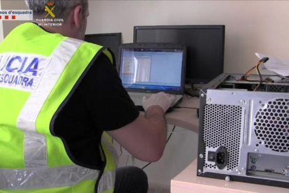 Un mosso inspecciona material incautado en una operación policial contra la pornografía infantil el año pasado.