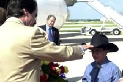 Aznar saluda a un muchacho con sombrero tejano en el aeropuerto de San Antonio