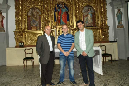 Avelino García, Jorge Martínez y Marcos Cachaldora con el retablo de San Andrés restaurado.