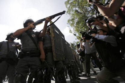 Un policía antidisturbios apunta con su arma a un grupo de manifestantes, durante la protesta en Sao Paulo de este jueves.