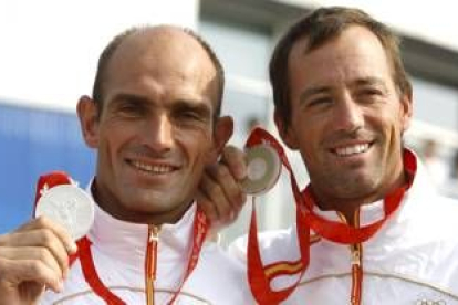 Los regatistas españoles Iker Martínez (d) y Xabier Fernández muestran la medalla de plata