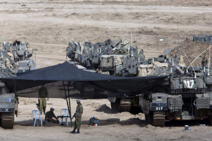 Varios soldados israelíes descansan entre los tanques al sur de Israel.