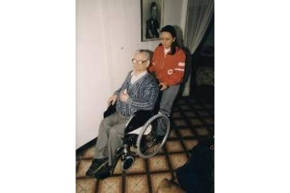 Una voluntaria de Cruz Roja visita a un anciano en su casa