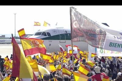 Casi a pie de pista, miles de fieles ondean sus banderas ante el avión que trasladó al Papa desde Roma hasta Madrid.