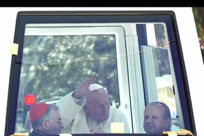 Juan Pablo II saluda desde el <i>Papamóvil</i> a los miles de fieles que se congregaron en Barajas para recibirlo.