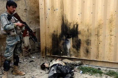 Un soldado afgano junto al cuerpo de un talibán muerto en un ataque en las cercanías de Kandahar.