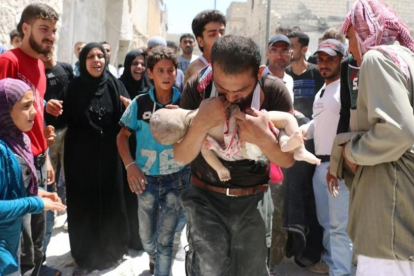 Un hombre sostiene el cuerpo sin vida de su hijo en brazos tras uno de los bombardeos en el barrio rebelde de Al-Marjah, en el norte de Alepo, este domingo.