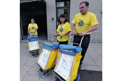 Tres carteros de Ponferrada con camisetas del Camino.