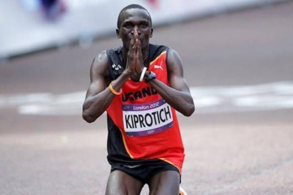 El atleta de Uganda, Stephen Kiprotich, celebra su victoria en la maratón arrodillado en el suelo. Foto: MAX ROSSI | REUTERS