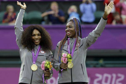 Serena y Venus Williams, las hermanas y pareja de tenistas estadounidense, muestran su tercer oro en dobles de tenis.