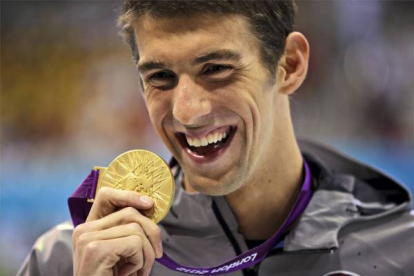 Michael Phelps muestra la medalla de oro lograda en 100 metros mariposa.