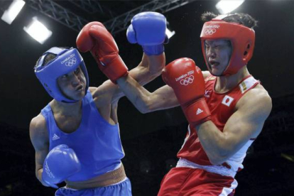 Yasuhiro Suzuki, de Japón, a la derecha, lucha contra Serik Sapiyev de Kazajistán.