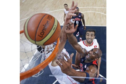 El estadounidense Kobe Bryant intenta meter canasta superando a Romdhane de Túnez durante el partido de baloncesto entre ambos países. Foto: REUTERS