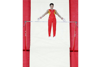 El gimnasta chino Zhang Chenglong realiza su ejercicio en la barra horizontal en la final de gimnasia artística masculina. Foto: AP