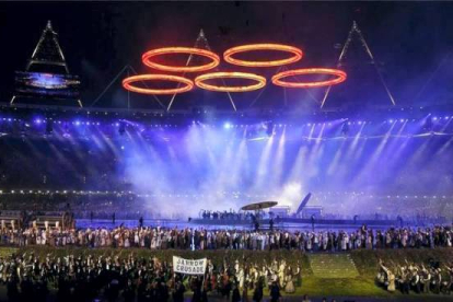 Momento en el que los aros olímpicos salen de una fundición representada en el escenario. Foto: JAE C. HONG | AP