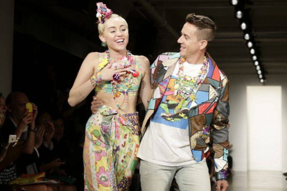 El diseñador estadounidense Jeremy Scott camina por la pasarela con la cantante estadounidense Miley Cyrus, tras presentar sus creaciones durante la semana de la moda de Nueva York.