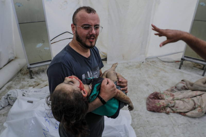 Un padre llora con su hijo muerto por el misil. MOHAMED SABER