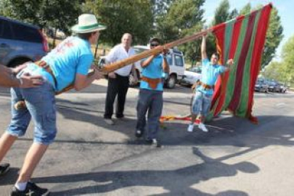 Uno de los grupos participantes en el desfile de pendones, en pleno esfuerzo por erguir la vara.
