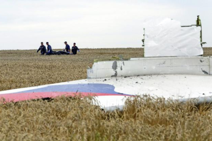 Varias personas transportan un cadáver en una camilla en medio de los destrozos de un Boeing 777, vuelo MH17 de Malaysia Airlines, derribado cerca de Donetsk (Ucrania).