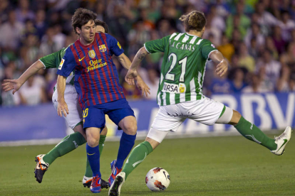 Messi conduce el balón entre Cañas y Beñat.