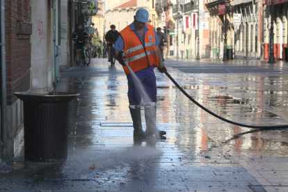 Empleado del Ayuntamiento limpiando las calles mediante baldeo manual. NORBERTO