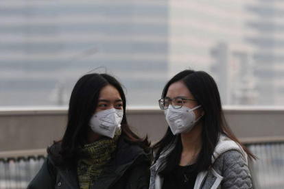 Dos chicas se protegen de la contaminación en Pekín el pasado lunes.