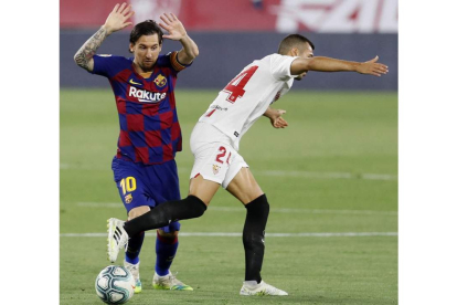 Messi, en pugna con un jugador del Sevilla en un lance del partido disputado en el Sánchez Pizjuán. VIDAL