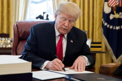 Trump firma la ley sobre la reforma fiscal, en el Despacho Oval de la Casa Blanca, en Washington, el 22 de diciembre.