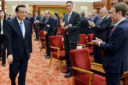 Zuckerberg (derecha) aplaude a la llegada del primer ministro chino, Li Keqiang, en una reunión empresarial en Pekín, el 21 de marzo.