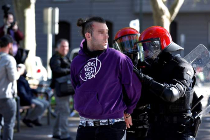 Los agentes de la Ertzaintza trasladan a un detenido en los incidentes de Bilbao.