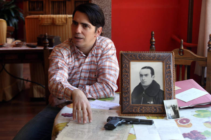 Javier Alonso de Quintanilla Peña, con el retrato de su abuelo, la pistola que empleó en vida y diversos documentos.