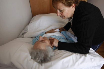 Una anciana dependiente recibe cuidados de una familiar en su casa.