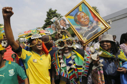 Varias personas cantan y bailan para rendir tributo a Mandela en Johannesburgo.