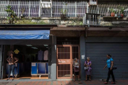 Un comercio abierto y otro cerrado en una calle de Caracas.