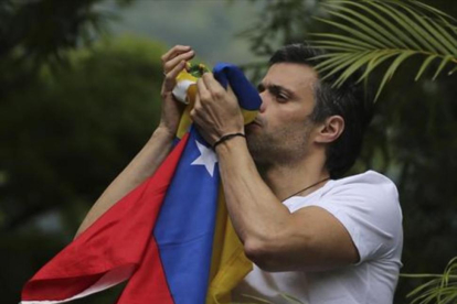 Leopoldo López besa la bandera venezolana tras ser liberado.