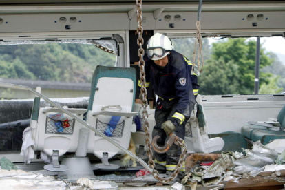 Un bombero trabaja en uno de los vagones del tren Alvia que descarriló en Santiago de Compostela.