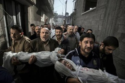 Imagen ganadora del World Press Photo, realizada en Gaza, donde una multitud que lleva en brazos a dos niños muertos tras un bombardeo israelí.