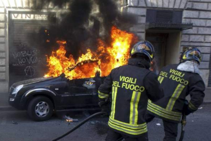 Los bomberos tratan de controlar las llamas de un vehículo ardiendo en el centro de Roma, Italia. Foto: EFE