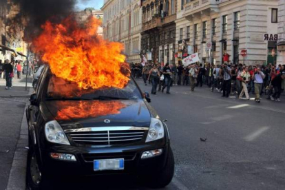 Un vehículo arde en el centro de Roma tras los incidentes acaecidos durante la marcha de los indignados por la ciudad. Foto: EFE