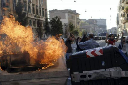 Un contenedor de basura arde en una barricada tras los incidentes que han tenido lugar durante la manifestación de los indignados en Roma, Italia. Foto: EFE