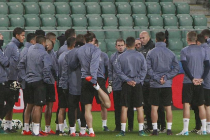 Los jugadores del Madrid escuchan a Zidane en el entrenamiento en el Ejército Polaco, campo del Legia.