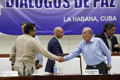 El comandante de las FARC y líder del equipo negociador de paz Luciano Marin 'Ivan Marquez' estrecha la mano del jefe negociador del Gobierno colombiano  Humberto de la Calle, el viernes.