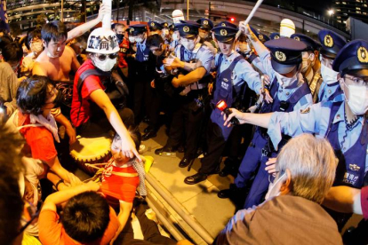 Manifestantes se enfrentan con las fuerzas de seguridad durante una protesta contra la celebración de los Juegos Olímpicos de Tokio 2020, este viernes frente al Estadio Olímpico, durante la ceremonia de inauguración. EFE/ Lavandeira Jr