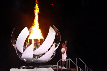 La tenista japonesa Naomi Osaka enciende el pebetero olímpico durante la ceremonia inaugural de los Juegos Olímpicos de Tokio 2020, este viernes en el Estadio Olímpico. EFE/ Enric Fontcuberta