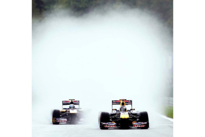 Vettel rueda por delante de Alguersuari bajo la lluvia de Spa.